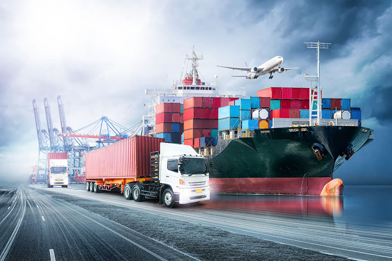Cargo containers on a ship and trucks at a dock
